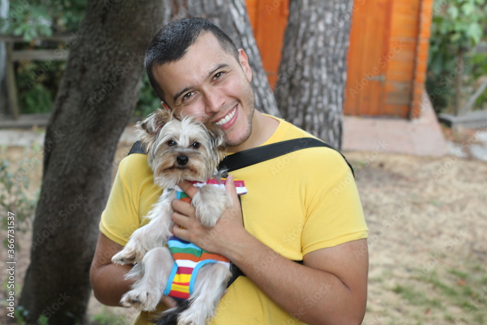 Handsome man carrying dog in striped backpack Handsome man carrying dog in striped backpack