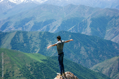 Man standing on top of a cliff at sunset