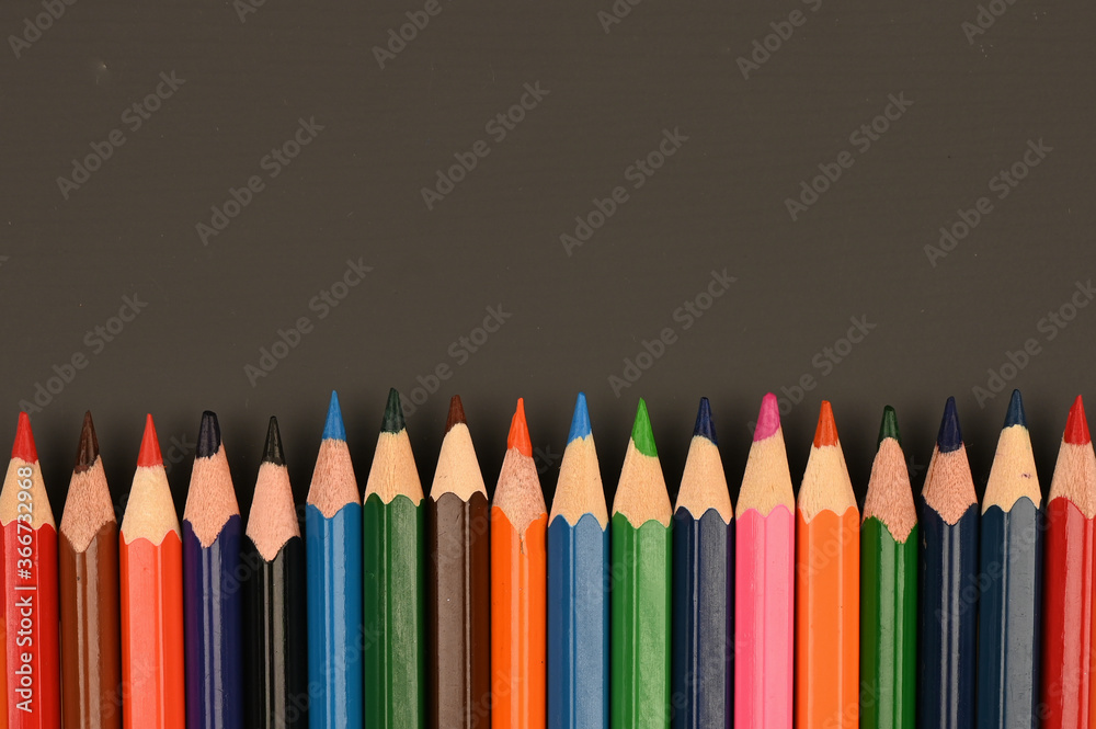 multicolored pencils on a dark school board