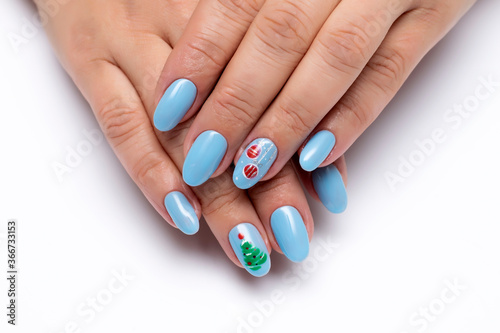 New Year s blue manicure with painted Christmas decorations and a Christmas tree on long oval nails