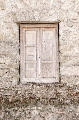 rustic wooden window in old stone house © Lourdes Balduque