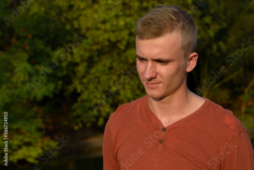 Young man with blond hair at the park outdoors