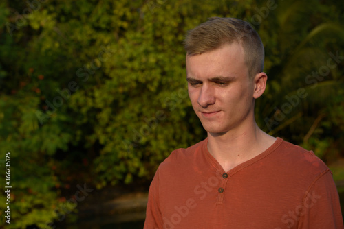 Young man with blond hair at the park outdoors