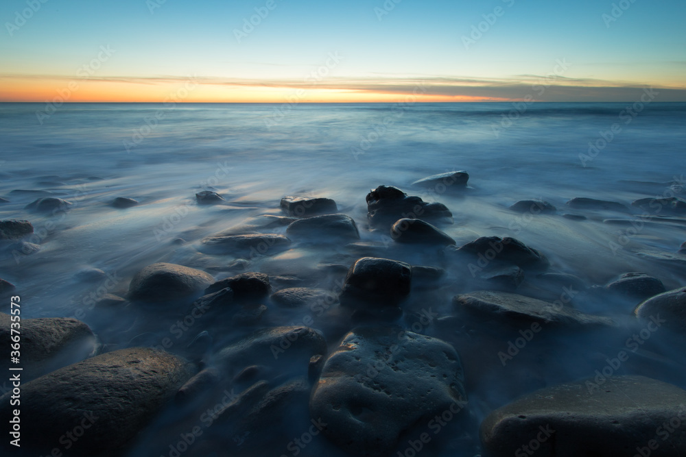 Obraz premium Magical beautiful Sunset at Rocky beach with Blue Ocean. Coastline landscape. Beautiful Scenic View.