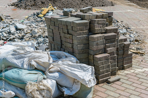 Construction waste in bags, broken stone and a pile of bricks during industrial work