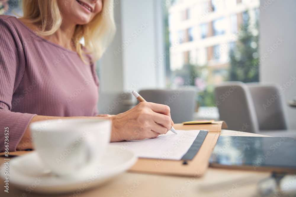 Positive delighted blonde looking at her notes
