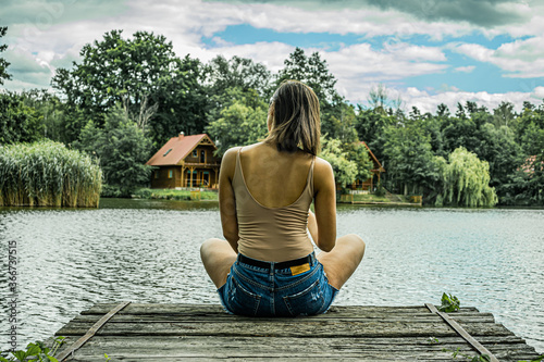 Girl sitting on a lake dock