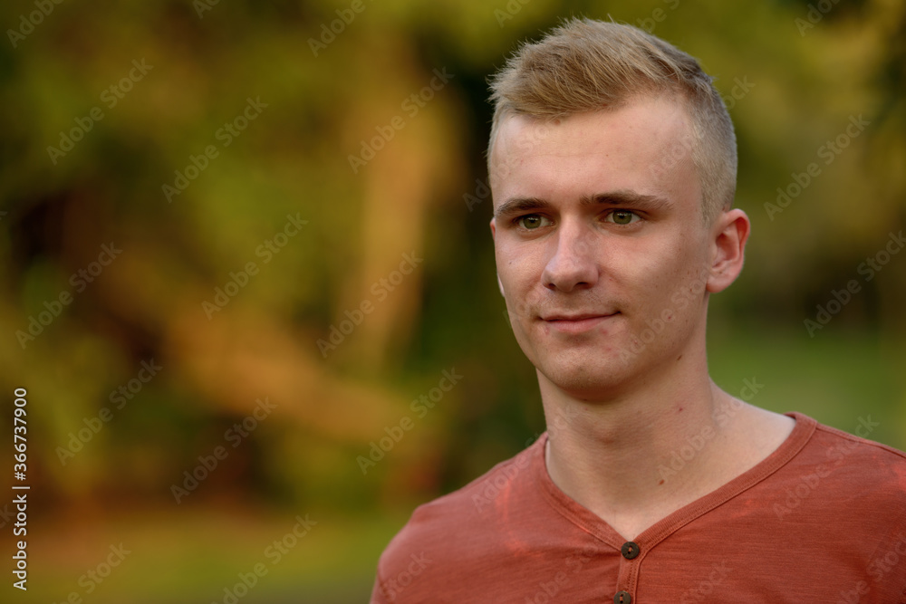 Young man with blond hair at the park outdoors