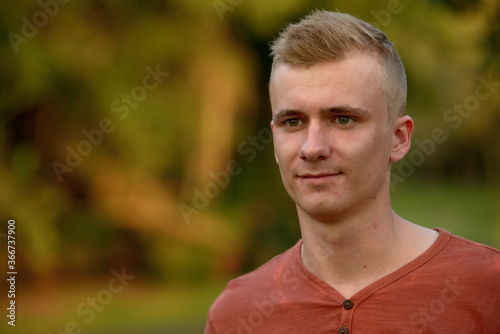 Young man with blond hair at the park outdoors