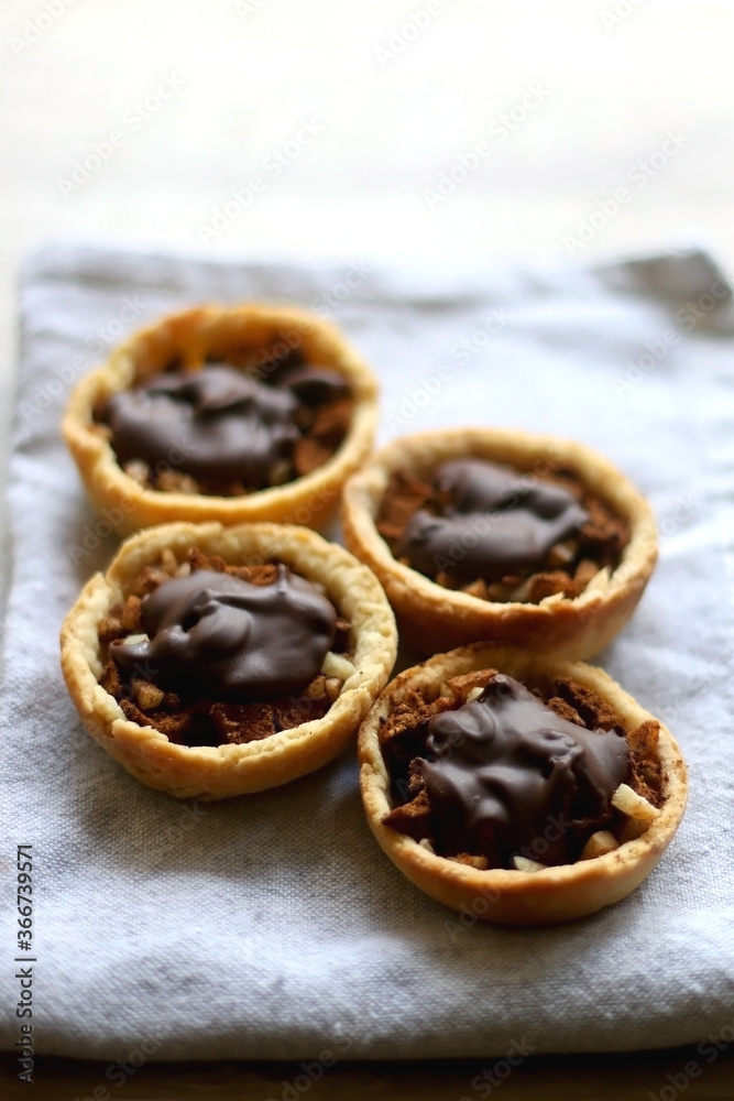 Pastry baskets filled with apples, almonds and dark chocolate. Selective focus.