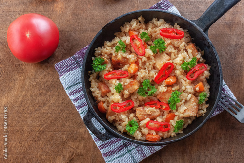 Rice with meat, vegetables and parsley in a serving pan