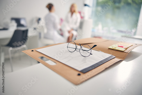 Close up of glasses lying on the notebook