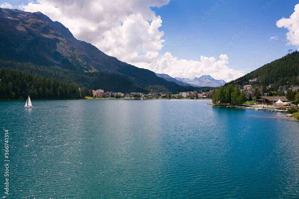 Summer walk in St. Moritz, Switzerland. Lake, paths, houses. Beautiful blue mountain lake. St. Moritz in the summer.