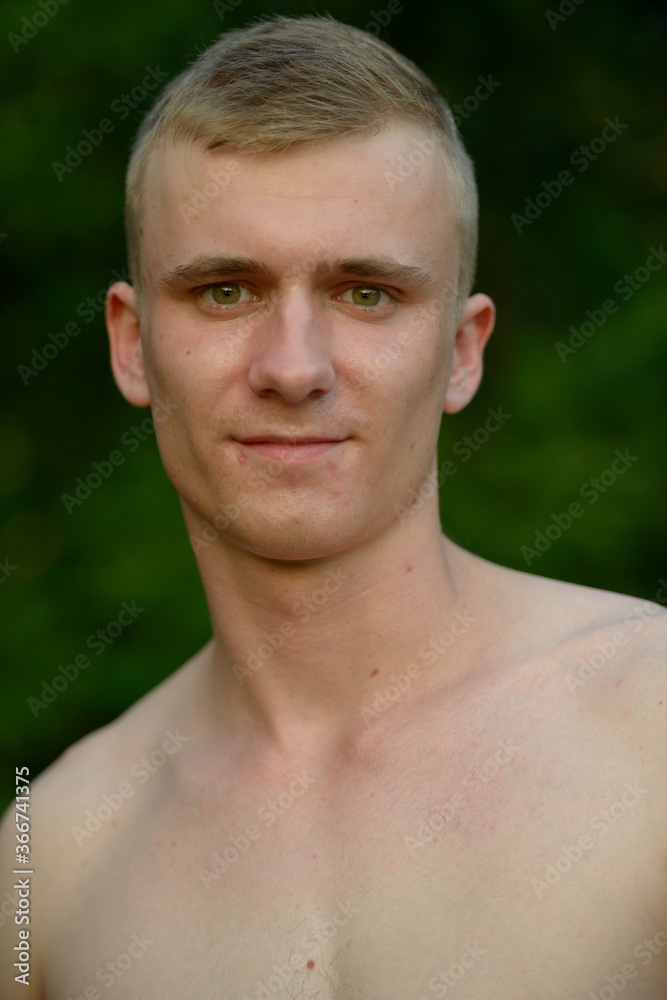 Obraz premium Young man with blond hair shirtless at the park outdoors