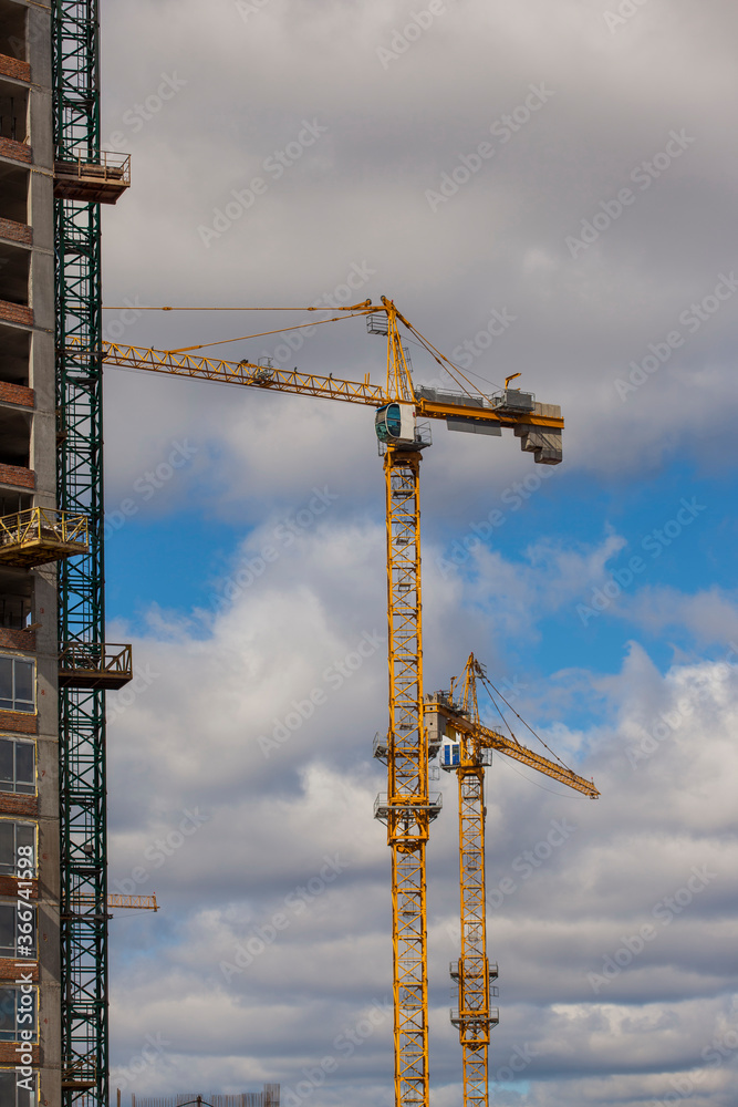 construction site with cranes against the cloudy sky
construction site with cranes against the cloudy sky