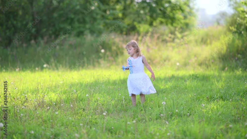 Happy Smiling Girl with Wooden Toy Plane Model Plays in the Field. Child Baby Dreams. SLOW MOTION Happy Smiling Girl with Wooden Toy Plane Model Plays in the Field. Child Baby Dreams. SLOW MOTION