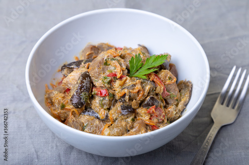 Pork with eggplant, tomatoes, peppers and carrots in a creamy sauce. Close-up.