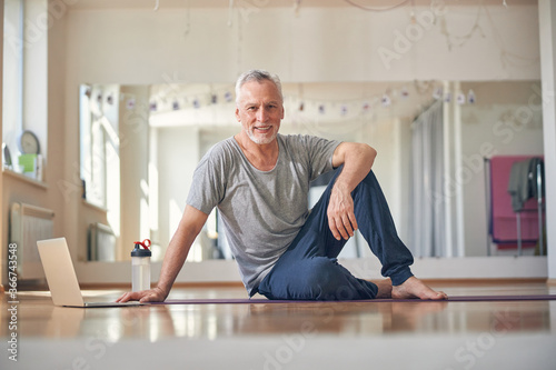 Sporty mature male sitting at a gym