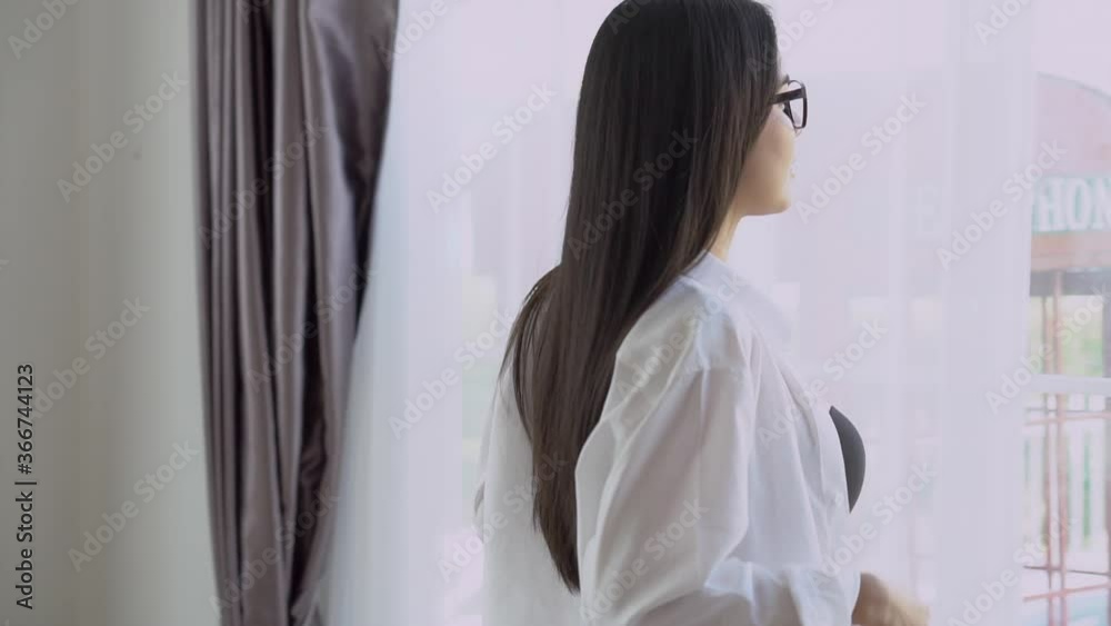 Beautiful young asian woman happy in underwear sexy walking to window and taking off clothes at home for resting, girl in lingerie is figure fit relax in the room in vacation, lifestyle concept.