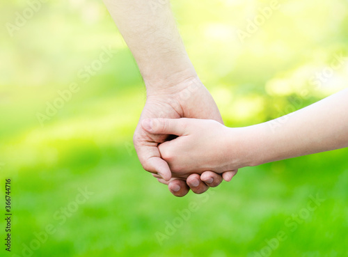Child holding father hand outdoors © svetamart