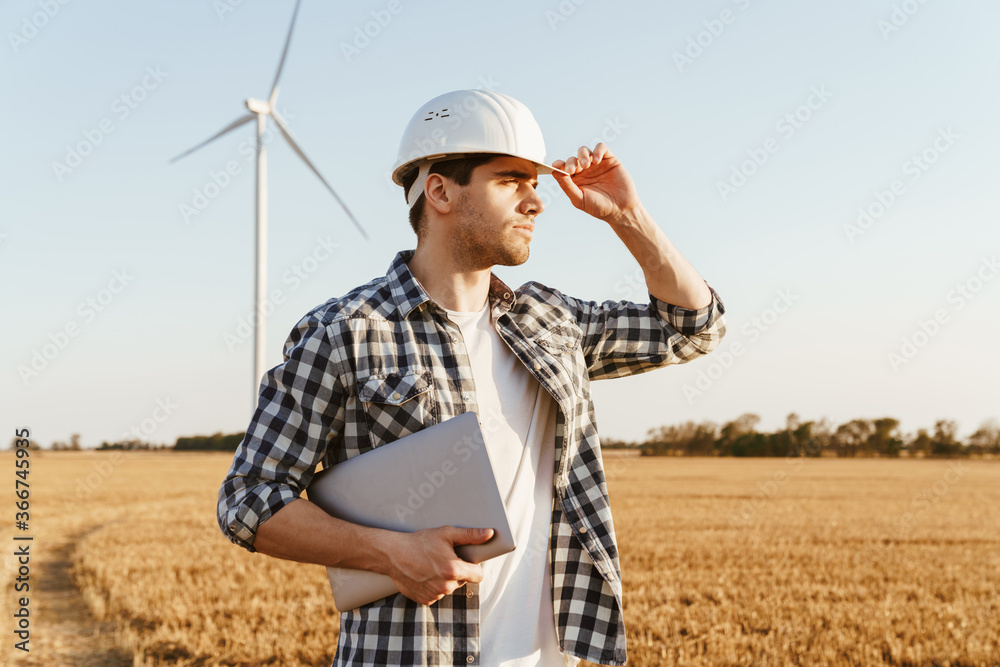 An electrical engineer standing on a field An electrical engineer standing on a field