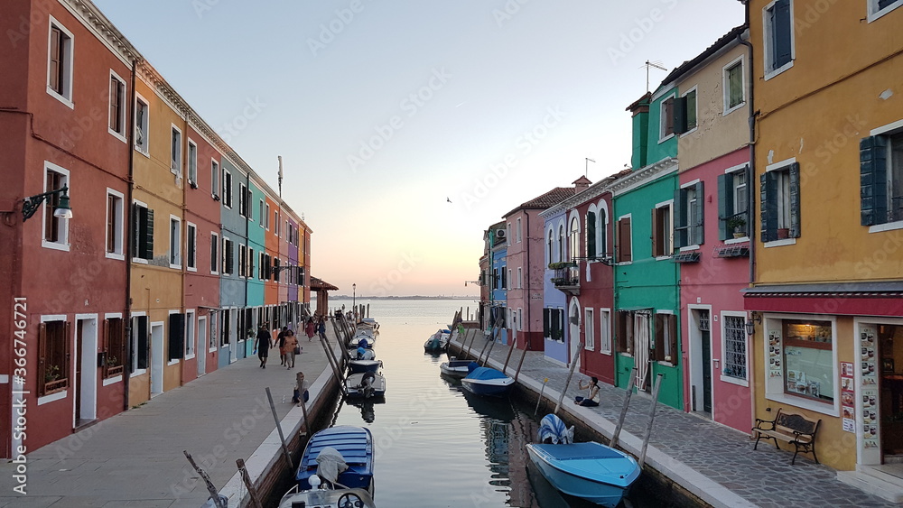 Burano, with sunset, gondola, water view, river view and reflection, an island in the Venetian Lagoon, Venice, northern Italy, lace work and brightly coloured (colored) houses and homes
