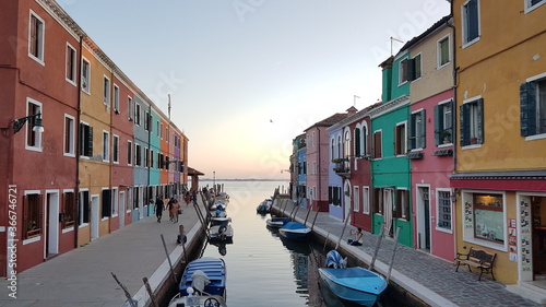 Burano, with sunset, gondola, water view, river view and reflection, an island in the Venetian Lagoon, Venice, northern Italy, lace work and brightly coloured (colored) houses and homes © filmonearth
