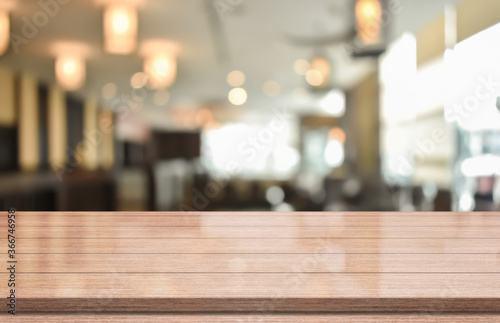 Empty wooden table top on blur coffee shop background