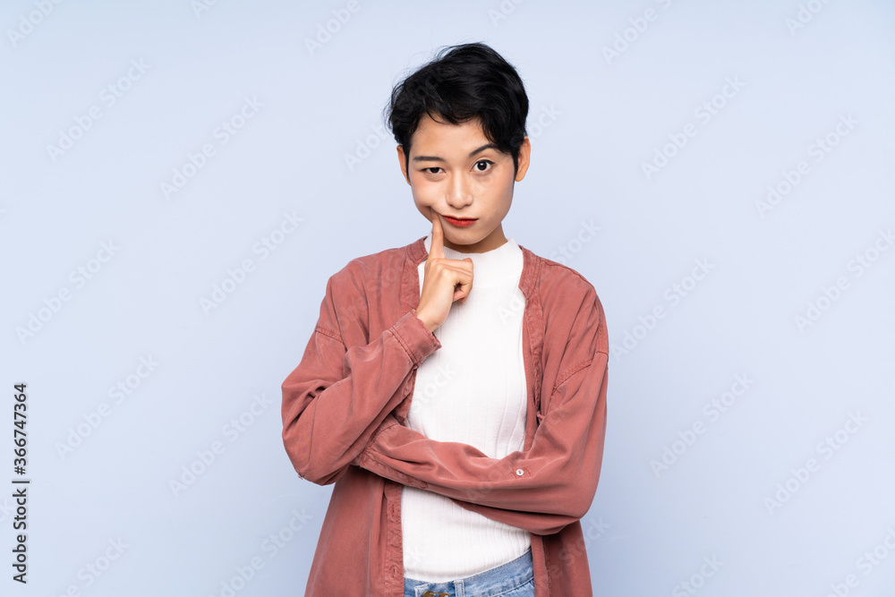 Young Asian girl over isolated blue background Looking front Young Asian girl over isolated blue background Looking front