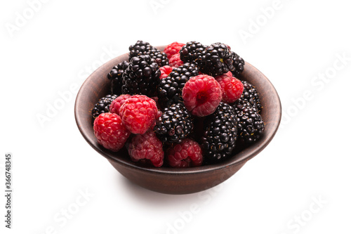 Raspberry  blackberry and mint leaf in ceramic brown bowl isolated on white