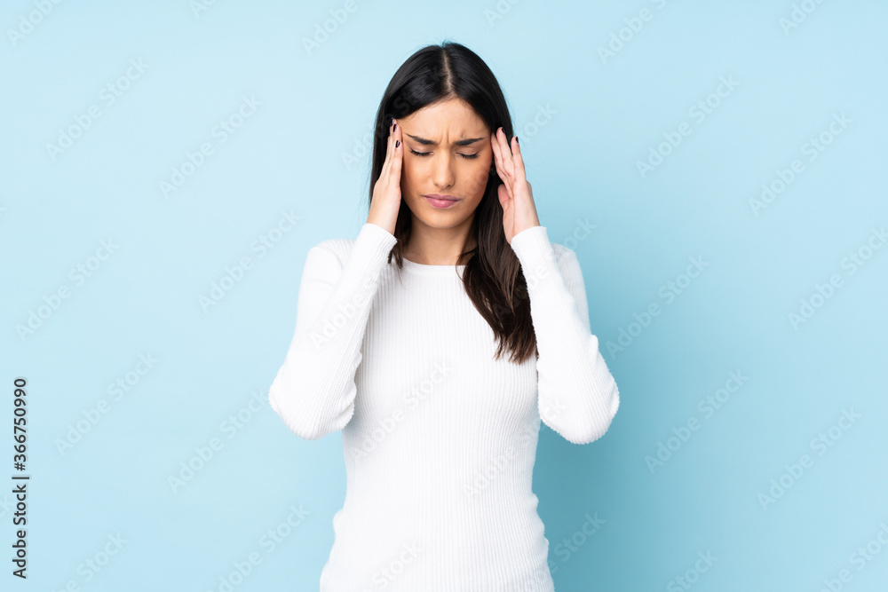 Young caucasian woman isolated on blue background with headache Young caucasian woman isolated on blue background with headache