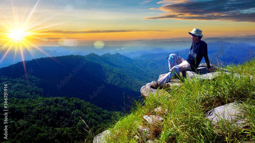 Naklejka premium Man relaxing alone on the edge cliff mountain with sunrise