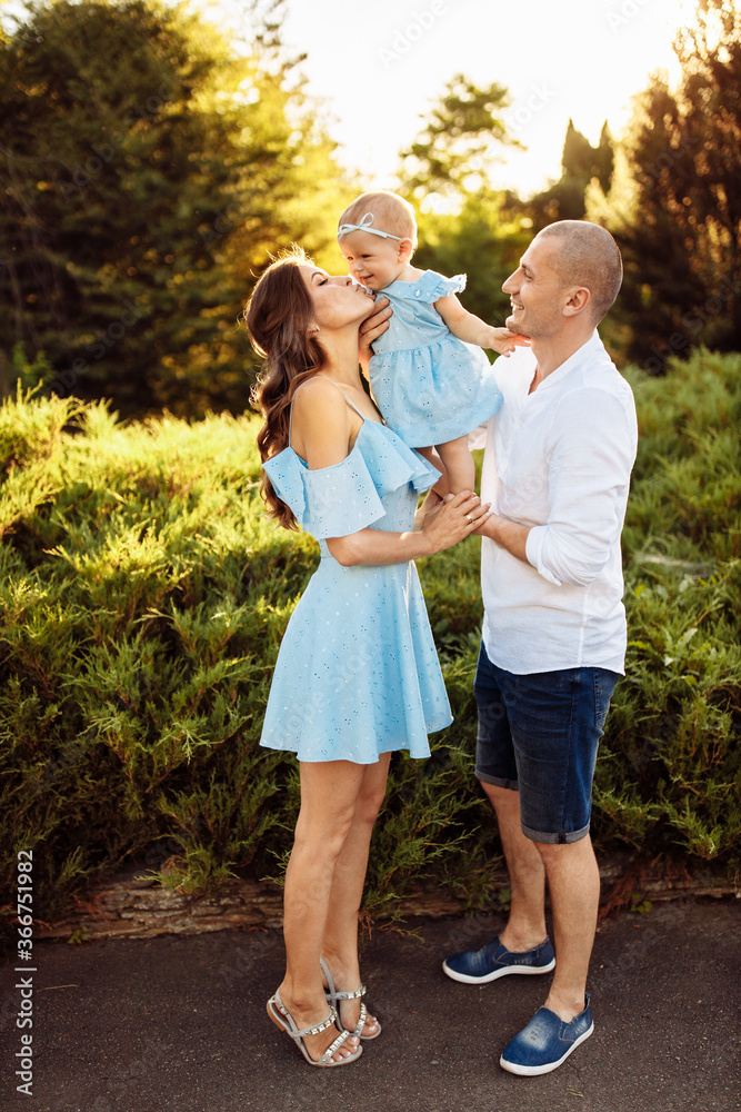 Fototapeta premium Loving overjoyed parents hold their adorable daughter