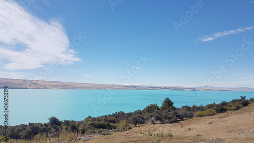 Lake Pukaki with mountain, white clouds, blue lake and sky in summer, the largest of three parallel alpine lakes running north–south along the edge of the Mackenzie Basin, South Island, New Zealand