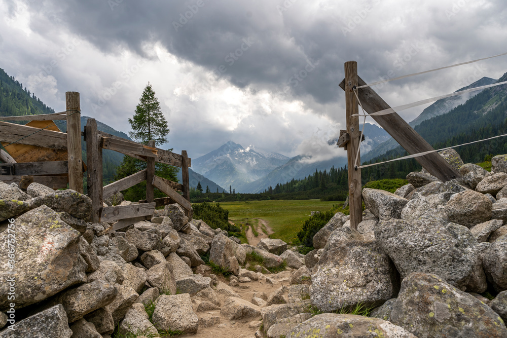 small path that goes through a wooden gate in the Dolomites
