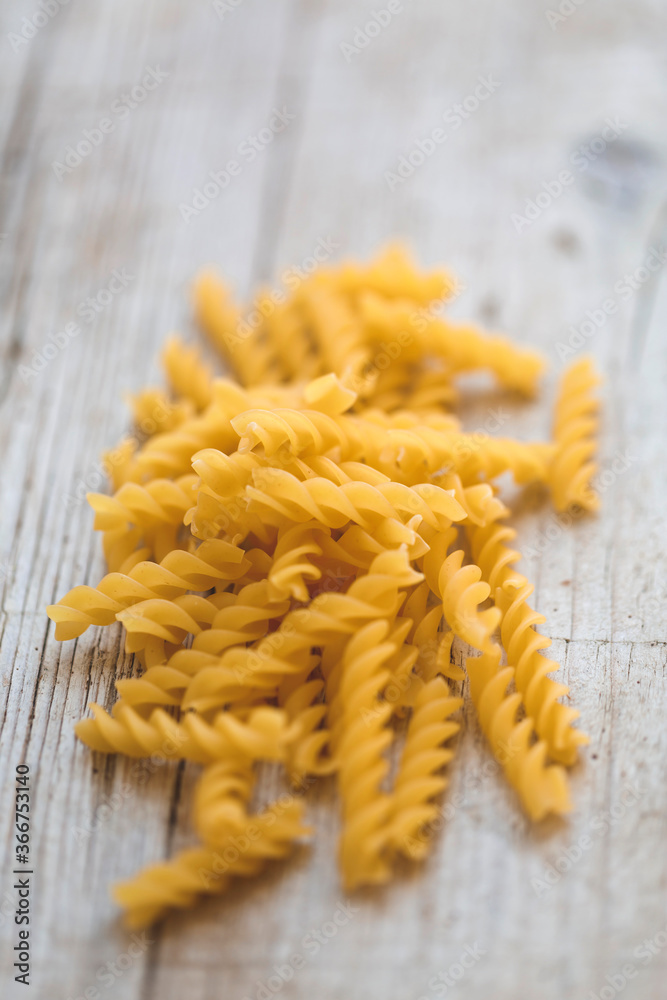a lot of different kinds of egg noodles and yellow pasta on wooden background a lot of different kinds of egg noodles and yellow pasta on wooden background