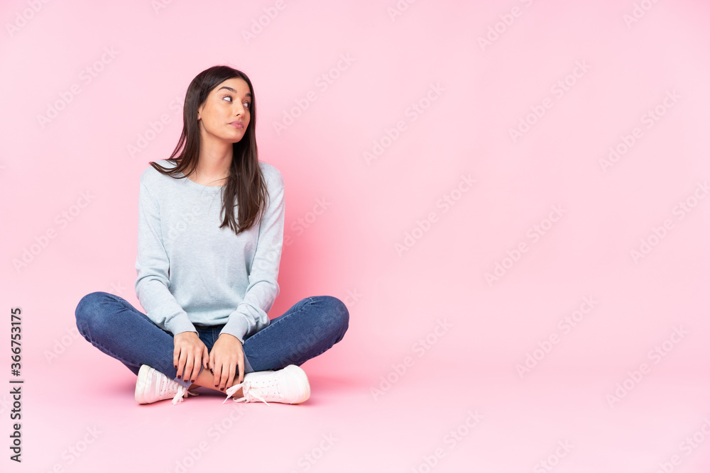 Young caucasian woman isolated on pink background making doubts gesture looking side Young caucasian woman isolated on pink background making doubts gesture looking side