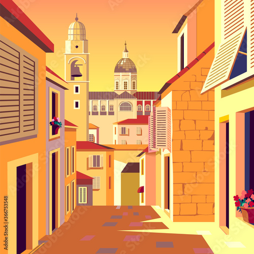 Old european street with traditional houses, church and ball tower in the background.