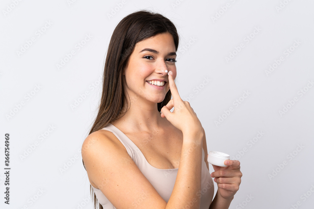 Teenager Brazilian girl with moisturizer over isolated white background Teenager Brazilian girl with moisturizer over isolated white background