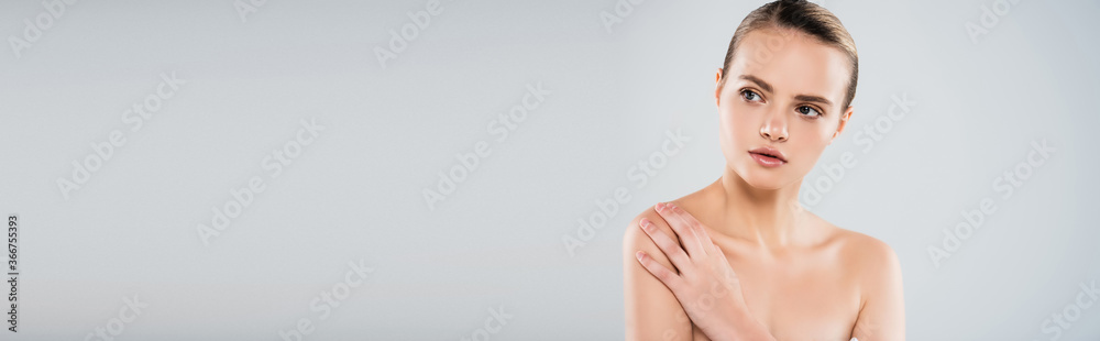panoramic crop of naked young woman looking away and touching shoulder isolated on grey panoramic crop of naked young woman looking away and touching shoulder isolated on grey