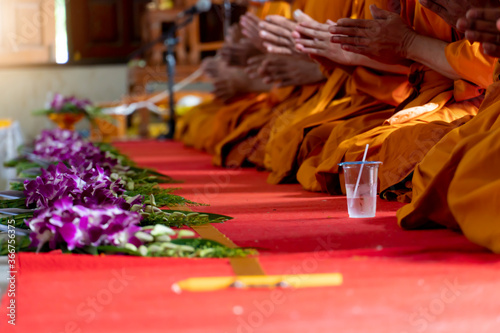 ฺBlurred of Monks chant along with holding the Sin line. There are orchids placed in front of the monks waiting to be delivered according to the Buddhist faith in Thailand.