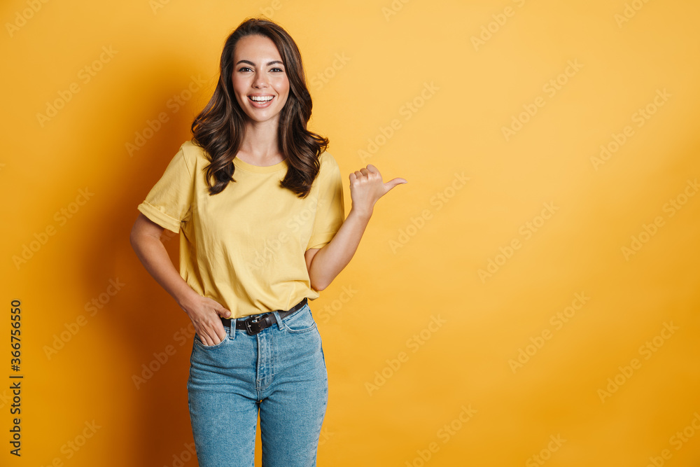 Obraz premium Image of joyful charming woman smiling and pointing finger aside