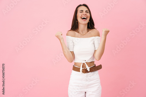 Image of delighted brunette woman screaming and making winner gesture