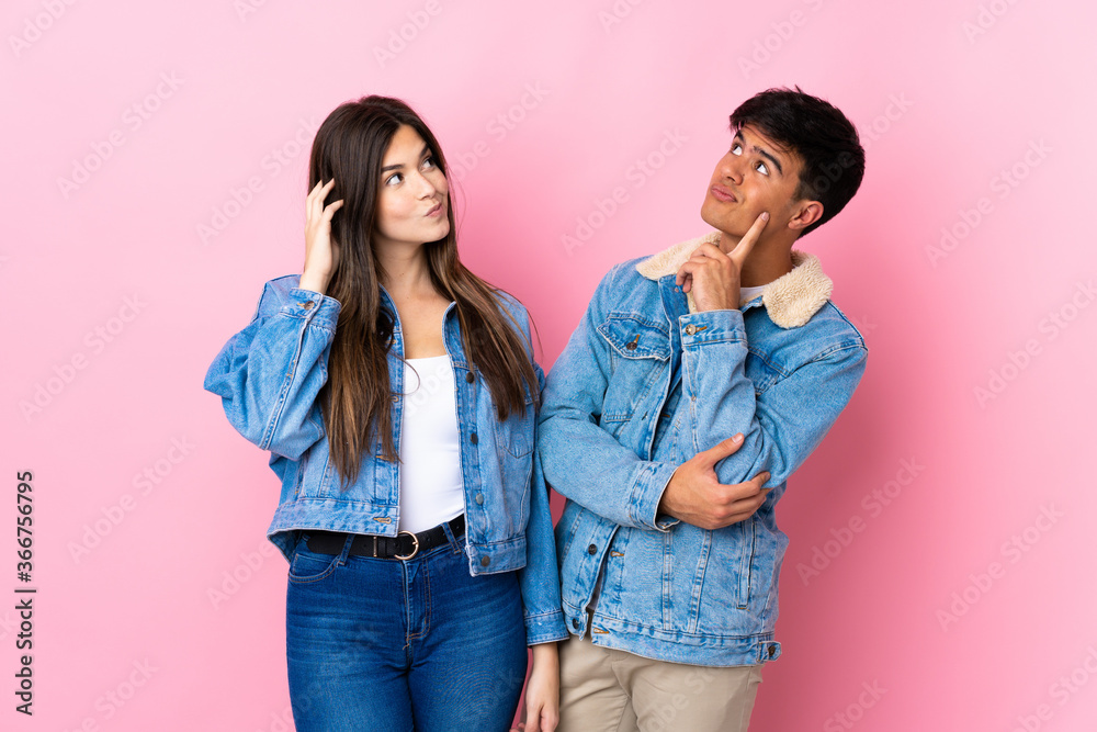 Young couple over isolated pink background thinking an idea while scratching head Young couple over isolated pink background thinking an idea while scratching head