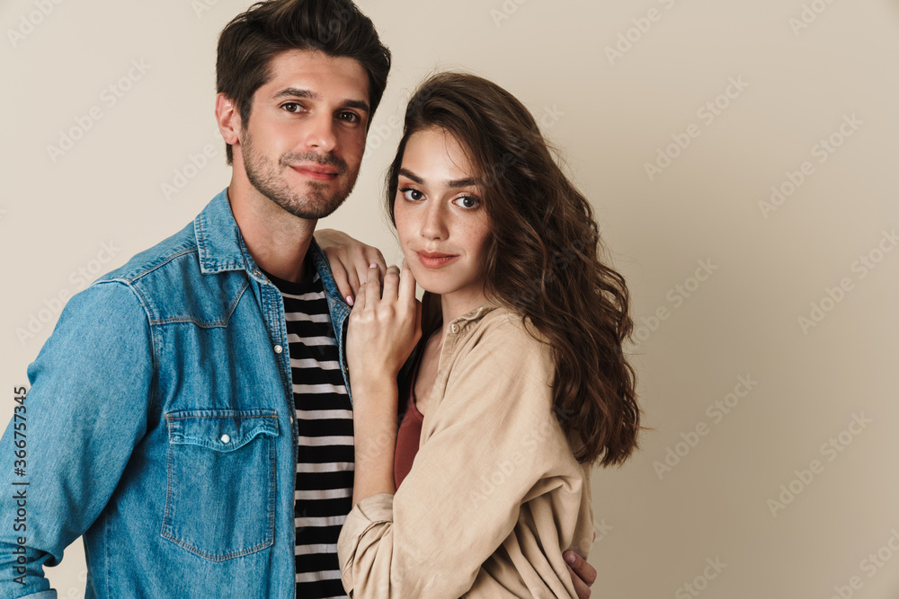 Image of young beautiful couple hugging and posing on camera Image of young beautiful couple hugging and posing on camera