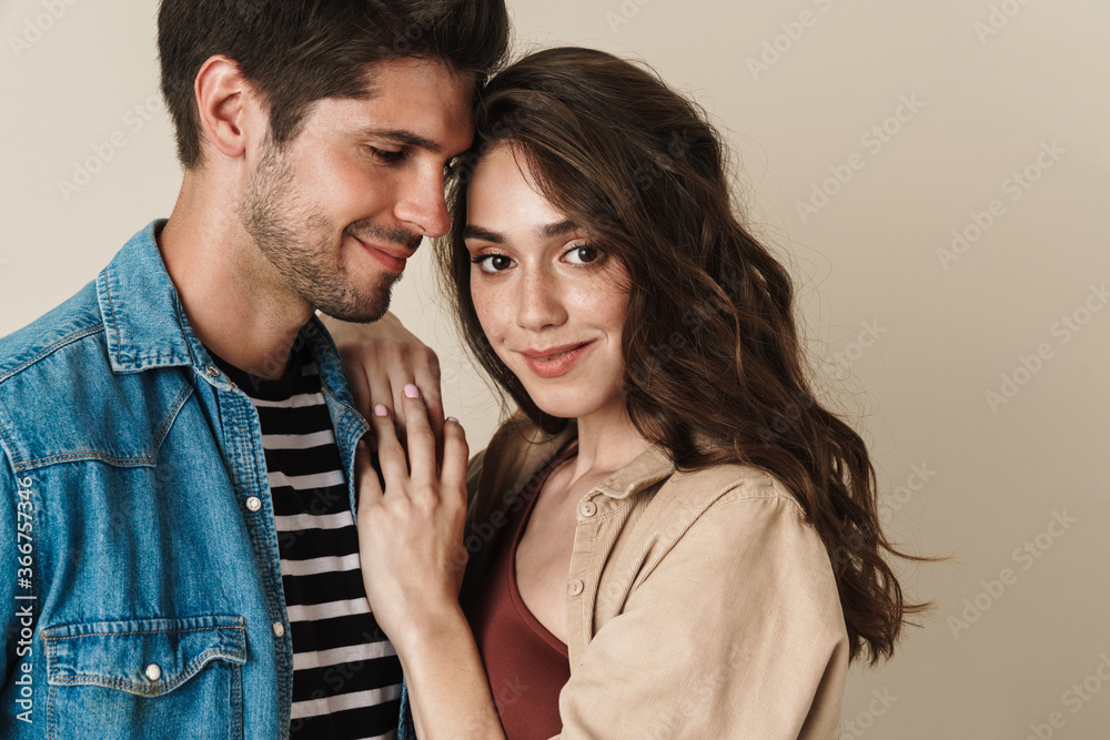 Image of cheerful beautiful couple hugging and smiling on camera Image of cheerful beautiful couple hugging and smiling on camera