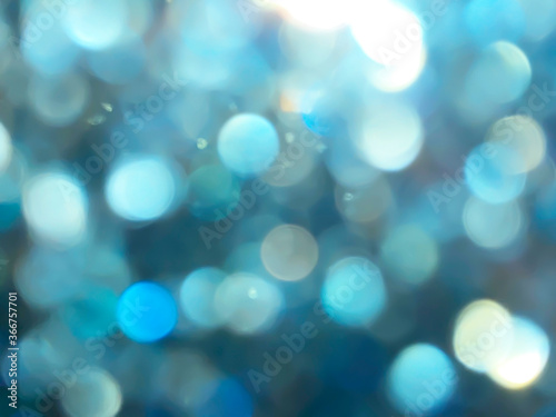 Abstract colorful Blue bokeh on glass in rainy day Look bright effect texture on black background. glitter lights defocused elegant for cosmetics or celebrate. Sparkling magical dust particles..