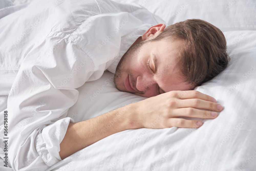Close-up portrait of sleeping brunette man on white pillow Close-up portrait of sleeping brunette man on white pillow