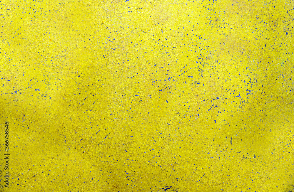 A wall with a textured rough surface in yellow