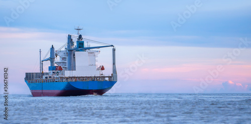logistics and transportation concept.cargo ship import export commerce sail boat at sea at twilight sky